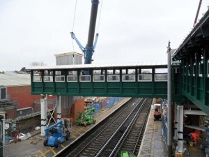 A large bridge section is lifted into place