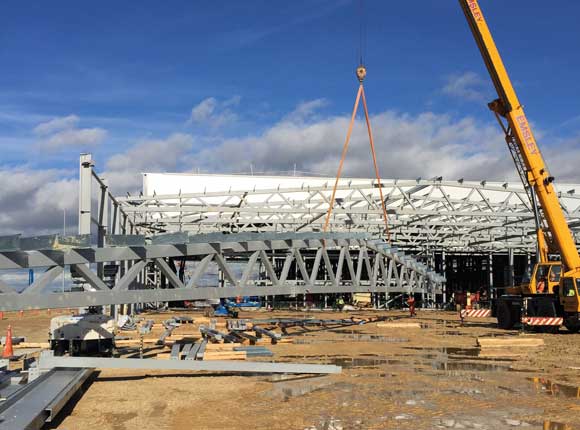 One of the large roof trusses is lifted into place